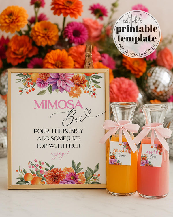 May include: A Mimosa Bar sign with floral decorations and text. Two glass carafes with pink bows and labels that read 'Orange Juice' and 'Apple Juice' are in front of the sign. The background features a colorful flower arrangement with orange, pink, and purple blooms.