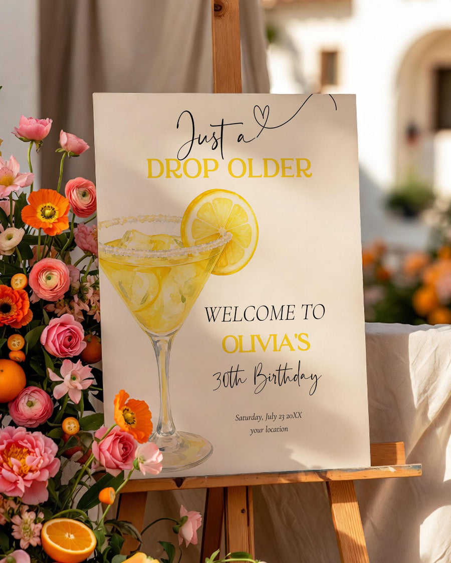 Just a Drop Older birthday welcome sign with watercolor lemon drop martini cocktail, lemon slice, yellow text, and editable party details.