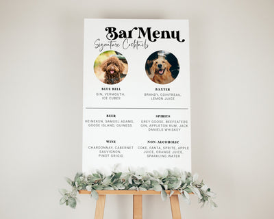 A digital cocktail sign displayed on a stand, featuring images of dogs and text detailing signature cocktails, with a decorative frame at the bottom.